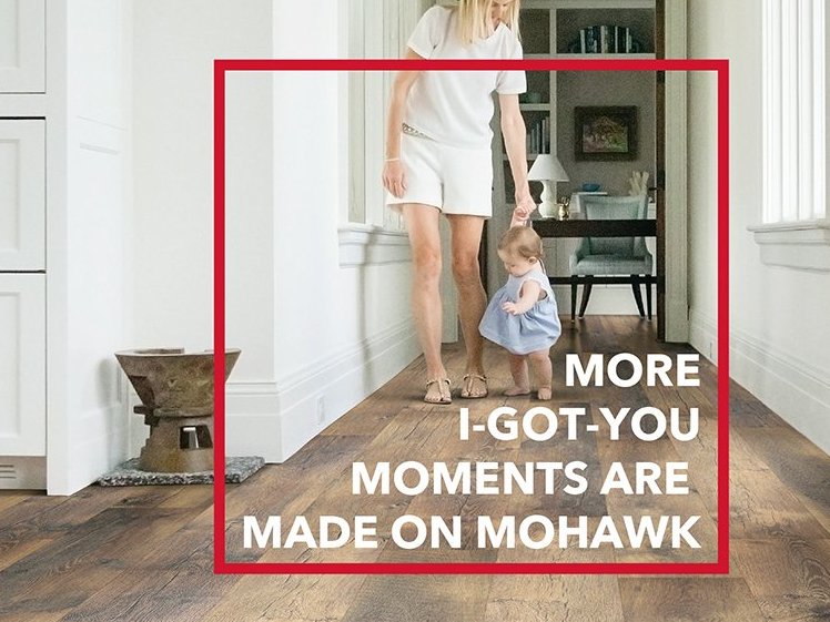 Mother hand holding walking baby on laminate flooring